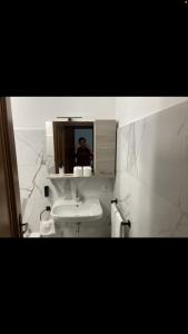 ミラノにあるAppartamento Loretoの浴室鏡で写真を撮る男
