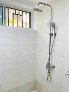 La salle de bains est pourvue d'une douche avec une porte en verre. dans l'établissement BUDGET HOMES ZANZIBAR, à Ngambo