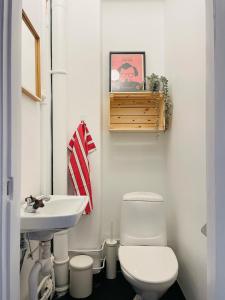 a bathroom with a white toilet and a sink at Cool and light 2 room apartment in SoFo in Stockholm