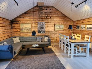 a living room with a couch and a table at Å Rorbuer - by Classic Norway Hotels in Å