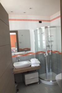 y baño con lavabo y ducha. en Residence Hotel Serenella, en Aprica