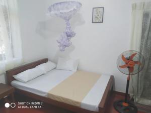 a bedroom with a bed with a fan next to it at Leisure Home Human Care Center in Gonawala