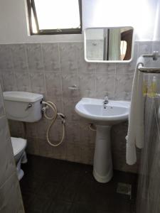 a bathroom with a sink and a toilet and a mirror at Leisure Home Human Care Center in Gonawala