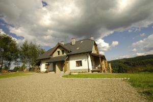 uma casa sentada em cima de uma estrada de cascalho em Biały Wierch Bieszczady em Polańczyk