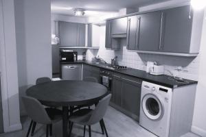 eine Küche mit einem Tisch und einer Waschmaschine in der Unterkunft Affordable Double room in Central London near Elephant and Castle station in London