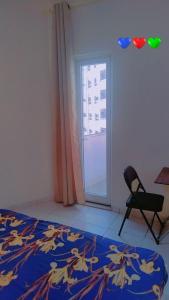 a bedroom with a bed and a chair and a window at Live Like A Family Home away from Home near Manila Super Market Opposite SAHARA Center near Al Nahda Park NMC Center Sharjah in Sharjah