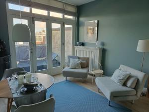 a living room with a table and chairs at Luxurious top apartment near beach, musea & Keukenhof in The Hague