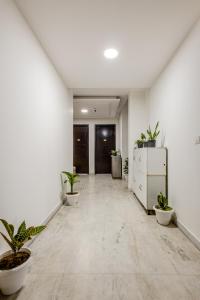 Lime Tree Service Apartment Golf Course Road, Gurgaon في جورجاون: ممر فارغ مع نباتات الفخار في مبنى