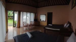 Cette chambre comprend deux lits, une table et des chaises. dans l'établissement Astradana Hotel & Glamping, à Kintamani