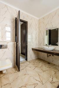 古爾岡的住宿－Lime Tree Service Apartment Golf Course Road, Gurgaon，一间带水槽、卫生间和镜子的浴室