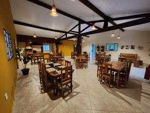 an empty restaurant with wooden tables and chairs at Espaço Chalé Cereja in Cachoeira Paulista