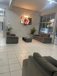 ein Wohnzimmer mit Sofas und einem Flachbild-TV in der Unterkunft Hotel Euzebio´s in Boa Vista