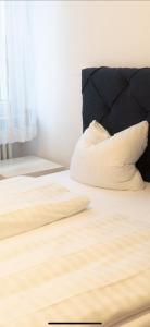 a bed with a black headboard and a white pillow at Haven - Hotel Am Stadion in Leverkusen
