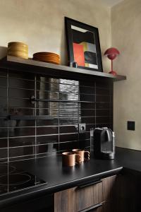 a kitchen with black tiled walls and a black counter top at Nafenna 2-Bedroom Apartment in OLD TOWN in Kraków