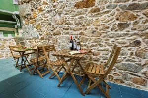 een tafel met 2 stoelen en flessen wijn bij A de Lucía in Muxia