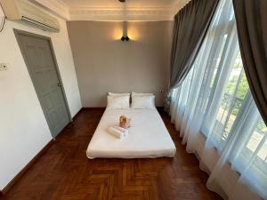 a dog sitting on a bed in a room with windows at Newly Renovated Seaview 3BR - 8Pax Baby Friendly in Kuah