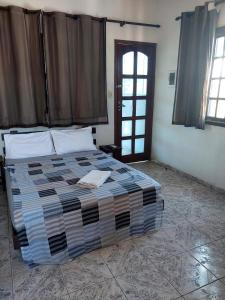 a bedroom with a large bed with a window at Suítes Independentes Praia dos Anjos in Arraial do Cabo