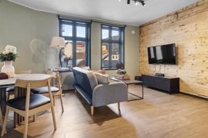 un salon avec une table, des chaises et une télévision dans l'établissement Elegant Urban Apartment, à Bergen