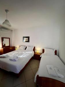 um quarto de hotel com duas camas com lençóis brancos em Balkon Bliss - Modern 1-BR in Central Tirana em Tirana