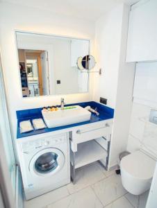 a bathroom with a washing machine and a sink at ORBI CITY -aparthotel in batumi in Batumi