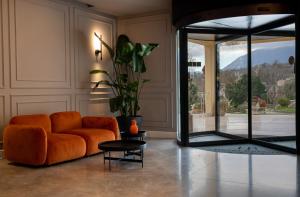 a living room with an orange couch and a glass door at Bel Sito Hotel Due Torri in Manocalzati