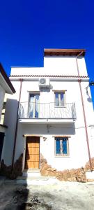 a white building with a door and a balcony at Sa Terra Mea - Luxury Apartment in Torpè