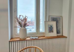a window sill with a vase with flowers on it at Modern&Quiet 7th floor Apt with Balcony, Free 5G WIFI, Laukontori in Tampere