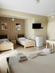 a room with two beds and a flat screen tv at Durmishi Rooms & Apartments & Beach in Sarandë