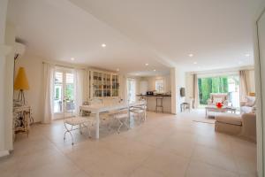 een keuken en een woonkamer met een tafel en stoelen bij Villa le Roi Soleil in Saint-Tropez
