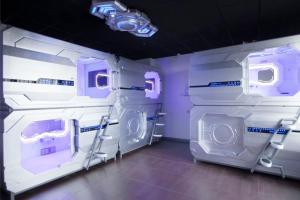 a room with two bunk beds with purple lights at Zhuhai Dreamers Capsule Hotel in Zhuhai