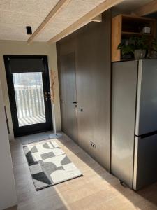 a kitchen with a refrigerator and a door with a rug at Bear House in Sigulda