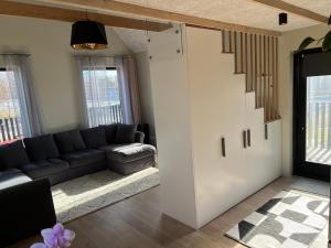 a living room with a couch and a stair case at Bear House in Sigulda