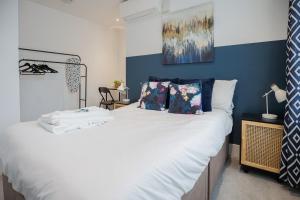 a bedroom with a large bed with blue walls at 1 Bedroom Apartment Urban Stay in Peterborough