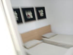 Private village apartment في Kirkop: غرفة بسرير وثلاث صور على الحائط