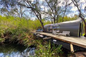 a train on a wooden platform next to a river at Bubble Lodge Ile aux Cerfs Island in Ile aux Cerfs