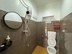 ein Bad mit einer Dusche, einem WC und einem Spiegel in der Unterkunft Lan Village in Mersing