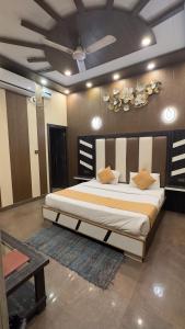 a bedroom with a large bed with a ceiling at Hotel Paradesi and Restaurant AJ Group in Haridwār