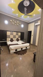 a bedroom with a large bed and a ceiling at Hotel Paradesi and Restaurant AJ Group in Haridwār