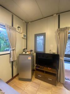 a room with a flat screen tv in a room at KORA-GREAT Airport Phuket in Nai Yang Beach