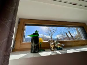 ein Fenster mit einer Statue eines Vogels auf einem Fensterbrett in der Unterkunft DAS MANFRED in Sankt Michael im Lungau