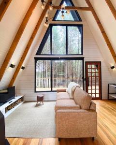 a living room with a couch and a large window at Cabana Alameda Black in Cambara do Sul