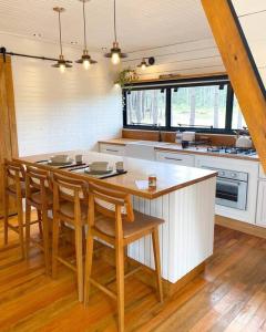 a kitchen with a table and some chairs in it at Cabana Alameda Black in Cambara do Sul +11 photos