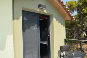 a door to a balcony with a table and a chair at Rastoni RQD 6 in Arkoudi +10 photos