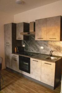 una cocina con electrodomésticos de acero inoxidable y armarios de madera en The Station Bollate Centro, en Bollate