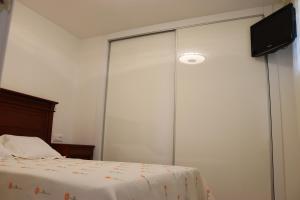 1 dormitorio con 1 cama y TV en la pared en Magnifico apartamento con vistas al mar, en Alicante