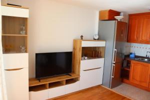 cocina pequeña con TV y nevera en Magnifico apartamento con vistas al mar, en Alicante