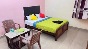 een slaapkamer met een bed en een tafel en stoelen bij Dwarka Residency in Mahabalipuram