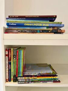 a stack of books sitting on a shelf at Highbury boho apartment in London