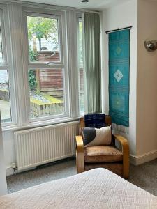 a bedroom with a chair in front of a window at Highbury boho apartment in London