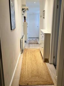 a hallway with a rug on the floor of a room at Highbury boho apartment in London